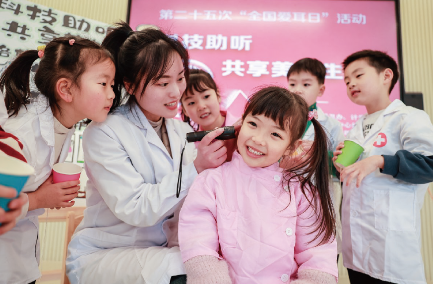 2024年3月1日，浙江省湖州市长兴县龙山街道中心幼儿园内，保健医生正在 为孩子们开展耳朵健康检查。